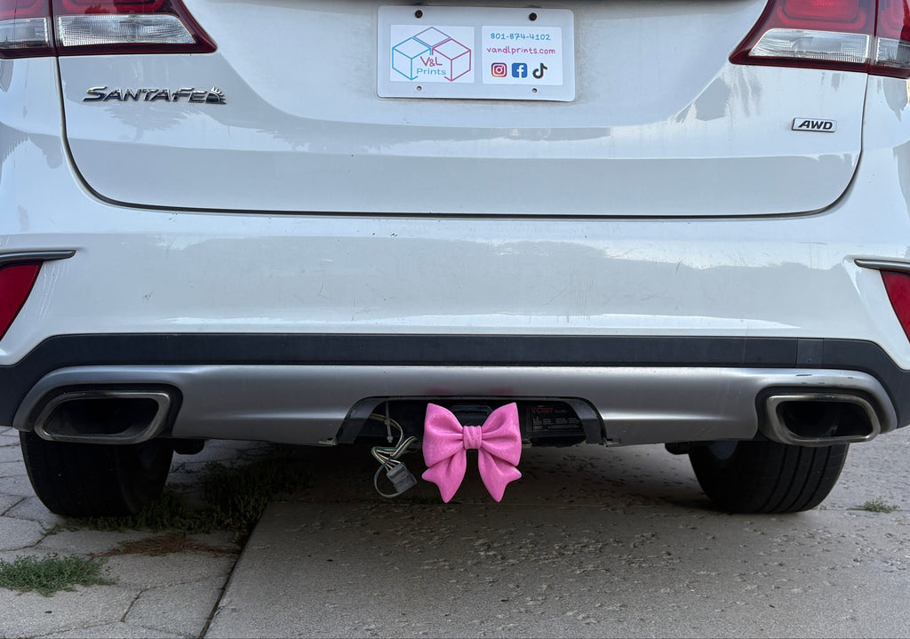 A Pink Bow Hitch Insert on a Car.